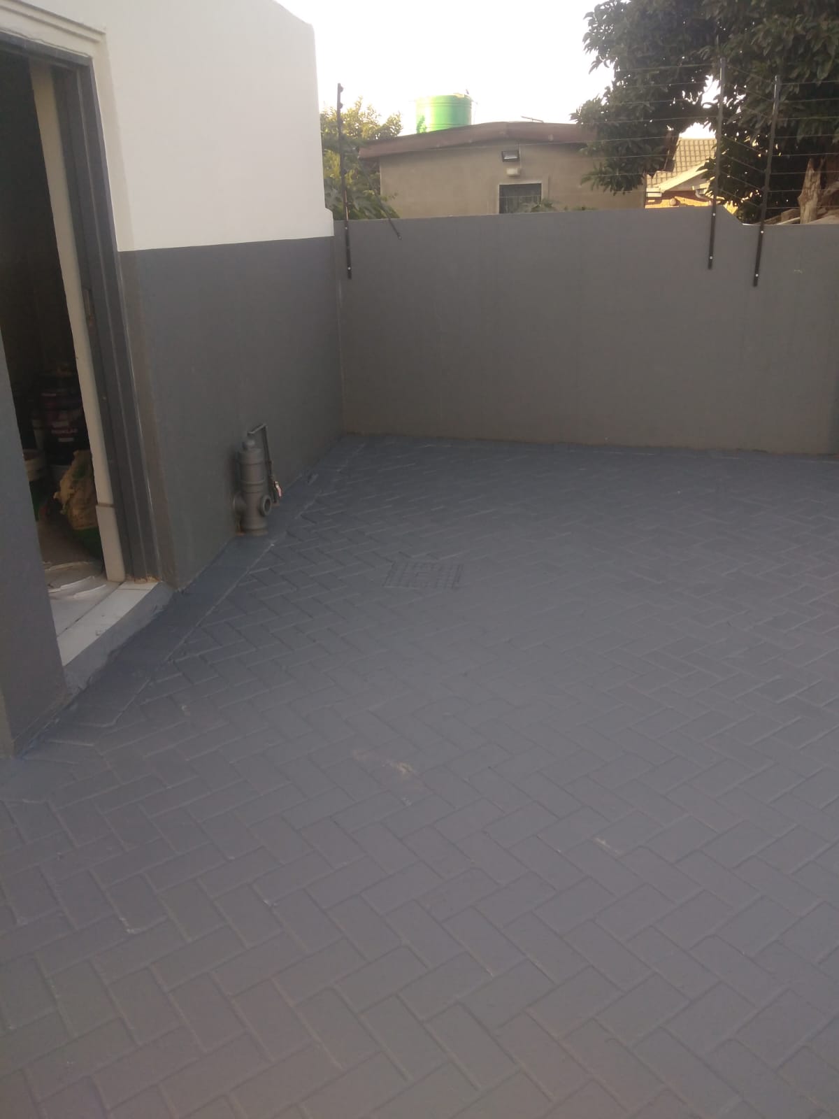 Paved courtyard before sealing with dull grey surface