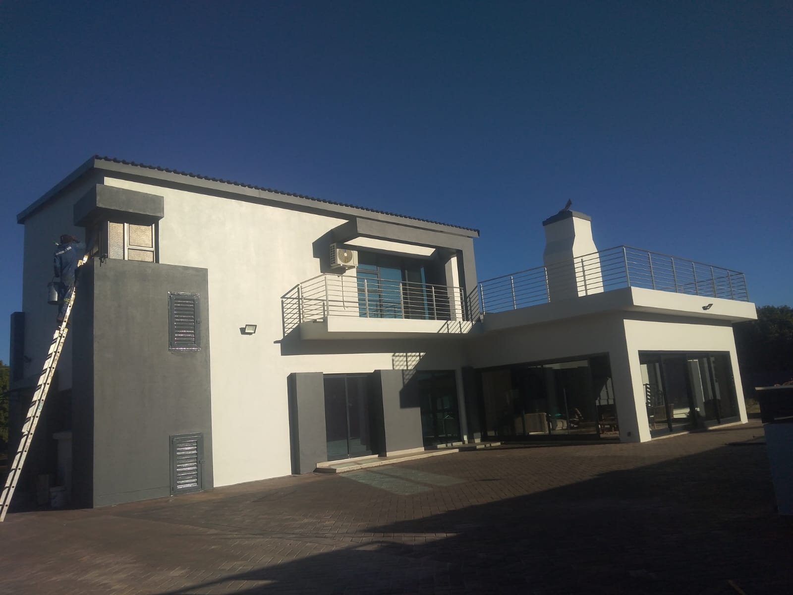 House exterior after painting in white with charcoal feature walls