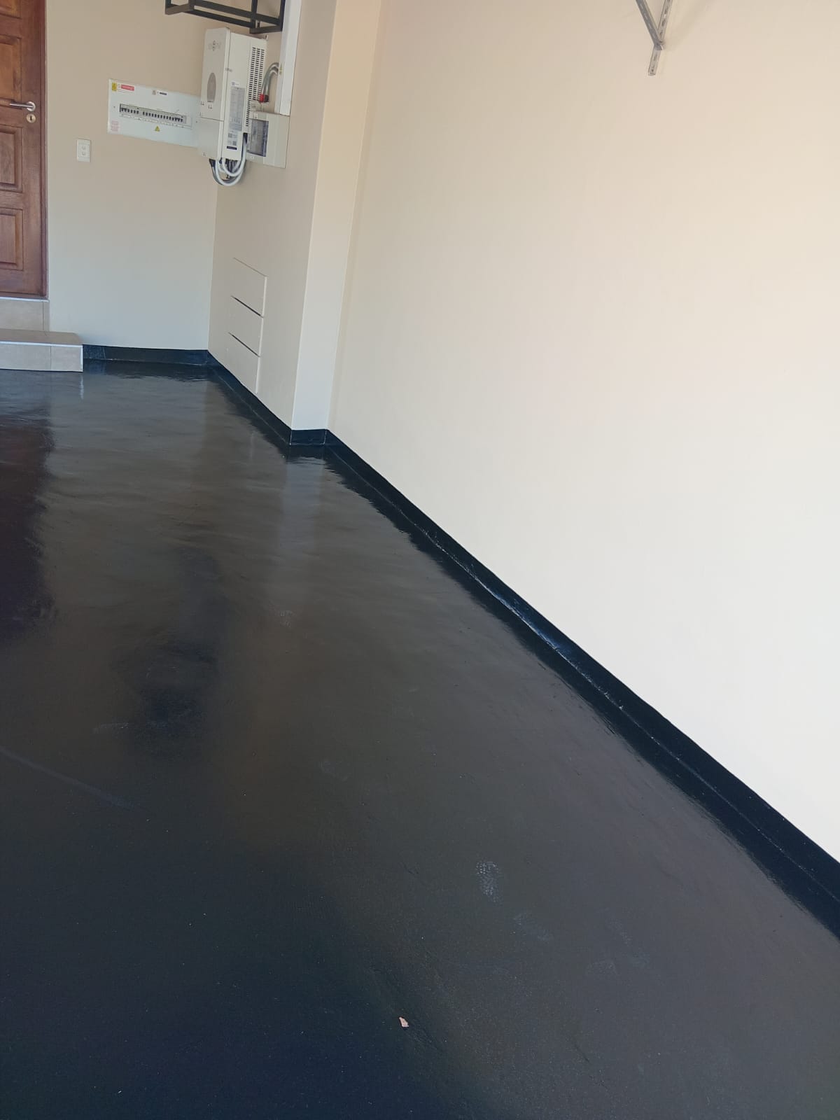 Glossy black epoxy garage floor coating with white walls
