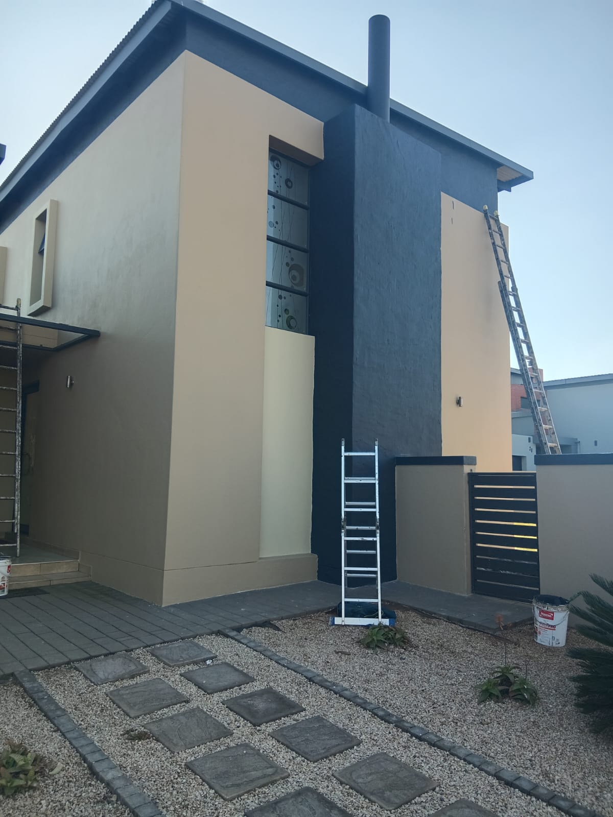 Exterior wall painting in progress with charcoal feature wall